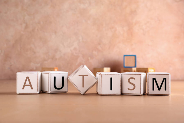 Word AUTISM made of cubes on color table - Photo, image