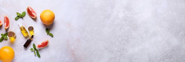 Эфирное масло, мята и грейпфруты на фоне гранжа с пространством для текста - Фото, изображение