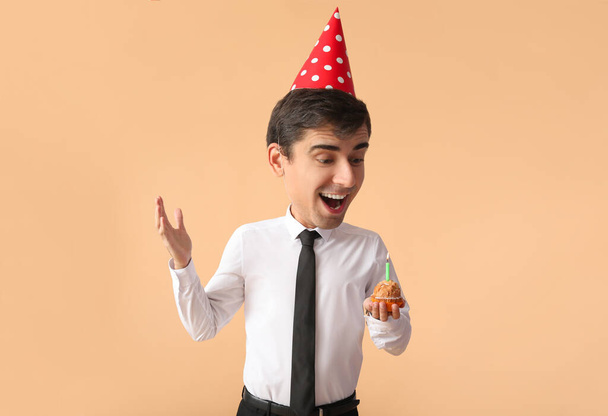 Happy funny businessman with big head celebrating birthday on color background - Photo, Image