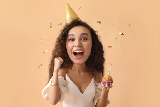 Young African-American woman with big head celebrating Birthday on color background - 写真・画像