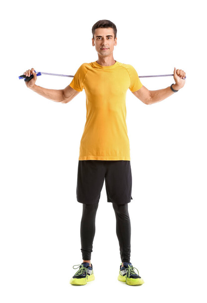 Sporty young man with jumping rope on white background - Φωτογραφία, εικόνα