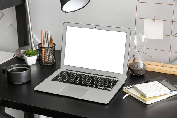 Moderner Laptop, Kaffeetasse, Notebook und Taschenrechner auf dem Tisch - Foto, Bild