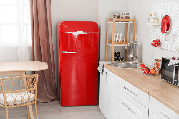 Інтер'єр світлої кухні з ретро холодильником, білими лічильниками і дошкою
 - Фото, зображення