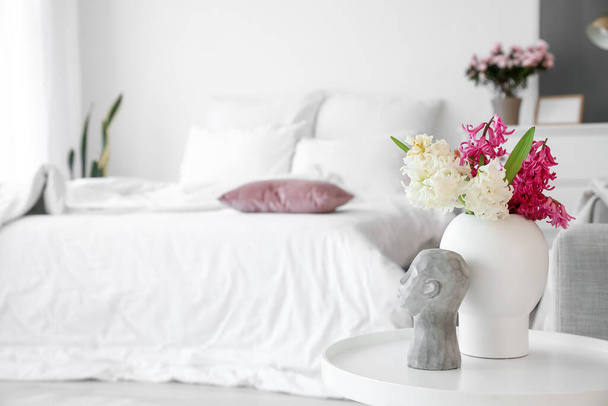 Maljakko kaunis hyasintti kukkia ja tyylikäs sisustus pöydällä makuuhuoneessa - Valokuva, kuva