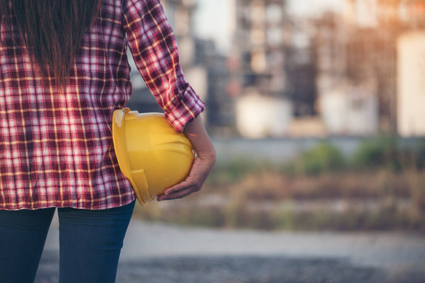 Refinery woman worker oil petro industry hand hold yellow worker helmet hard hat. Woman worker hands holding hardhat yellow work helmet Construction Engineer. Refinery industry engineer manufacture - Foto, immagini