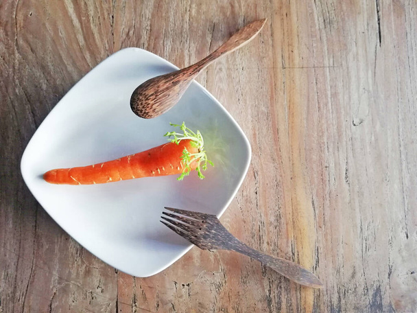 Growing carrots,placed on brown wooden background - Photo, Image