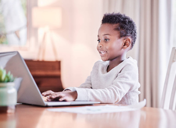 Er is geen einde aan onderwijs. Shot van een jonge jongen doet zijn huiswerk op een laptop thuis. - Foto, afbeelding
