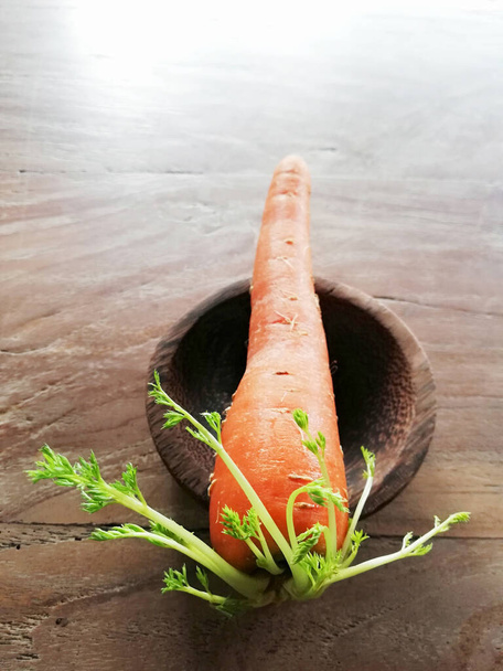 Growing carrots,placed on brown wooden background - Photo, Image