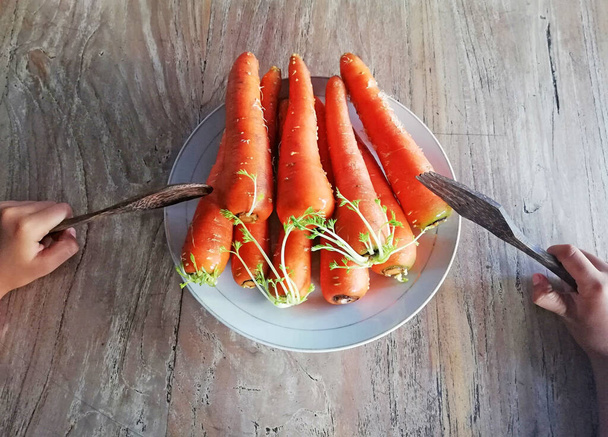 Zanahorias cultivadas, colocadas sobre fondo de madera marrón - Foto, imagen