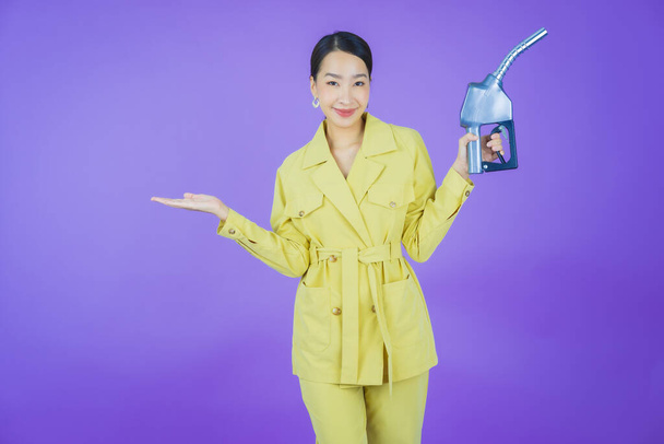 Portrait belle jeune asiatique femme querelle pompe à essence sur fond de couleur - Photo, image