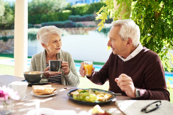 Este tipo de amor es para siempre. Foto de una pareja de ancianos cariñosos disfrutando de una comida juntos al aire libre. - Foto, Imagen