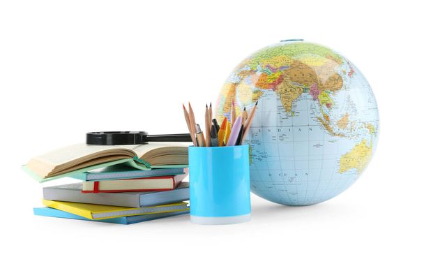 Plastic model globe of Earth, colorful pencils, magnifying glass and books on white background. Geography lesson - Фото, зображення