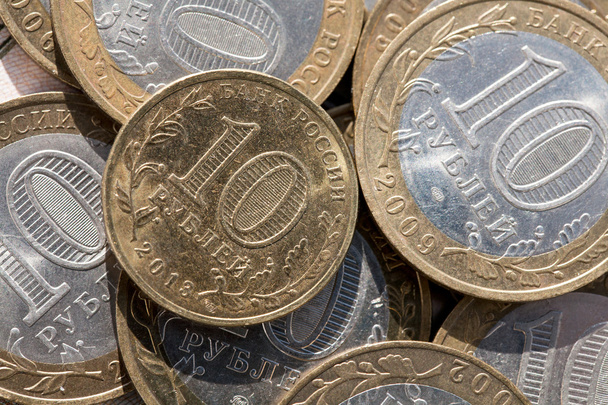 Moneda diez rublos en un papel de fondo notas por valor de cien rublos
 - Foto, imagen
