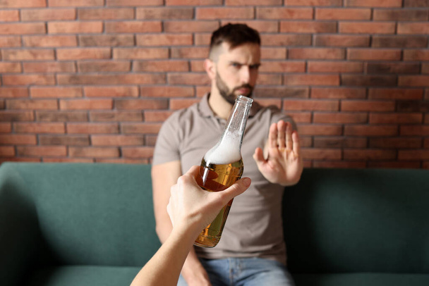 Man refusing to drink beer indoors, closeup. Alcohol addiction treatment - Foto, imagen