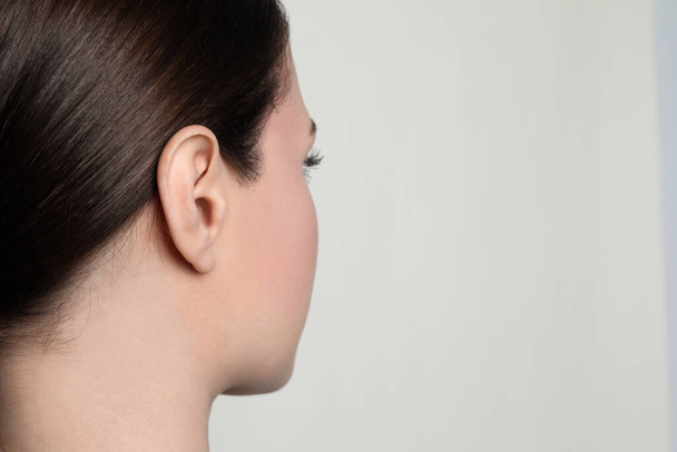 Woman on light background, closeup of ear. Space for text - Fotografie, Obrázek