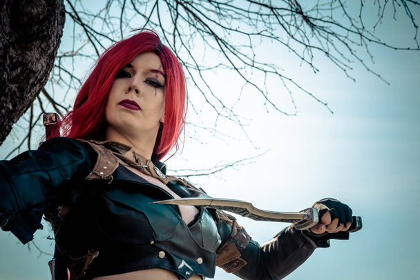 a woman with red hairs as a warrior with daggers in her hand - Photo, Image