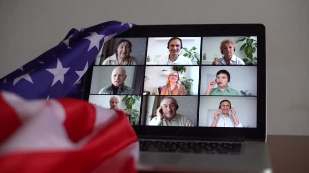 アメリカからの愛する人とオンラインパーティー。ビデオチャットを祝う。ビデオメッセンジャーを介して仮想パーティー。アメリカ人はビデオチャットです。コンピュータの横にあるアメリカの旗は - 映像、動画