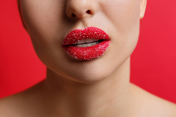 Closeup view of woman with lips covered in sugar on red background - Foto, immagini
