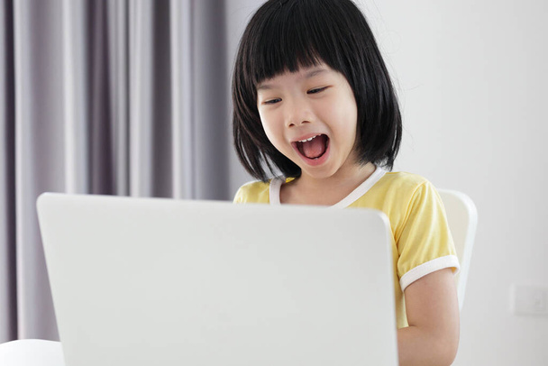 kis ázsiai lány diák tanulmány online segítségével laptop otthon - Fotó, kép