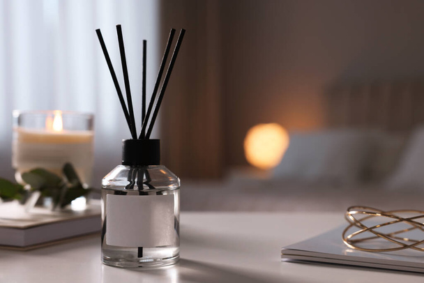 Reed diffuser on white table indoors. Space for text - Fotoğraf, Görsel