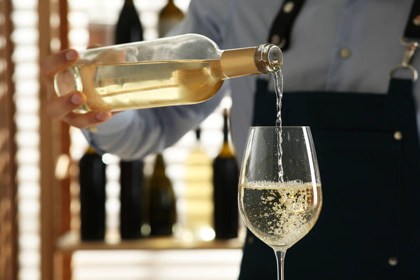 Bartender pouring wine into glass in restaurant, closeup - Фото, зображення