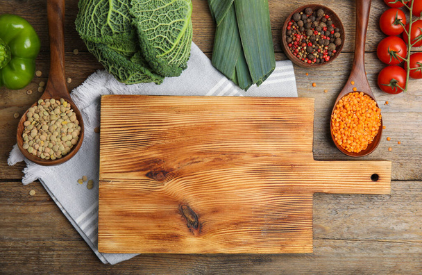 Board and different ingredients on wooden table, flat lay with space for text. Cooking classes - Fotografie, Obrázek