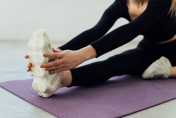 Fit woman stretching her leg to warm up over white background - Zdjęcie, obraz