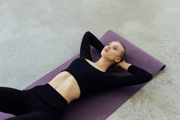 Desportivo jovem atleta no tapete de ioga fazendo situps no ginásio. Mulher fitness fazendo abdominais crunches. - Foto, Imagem