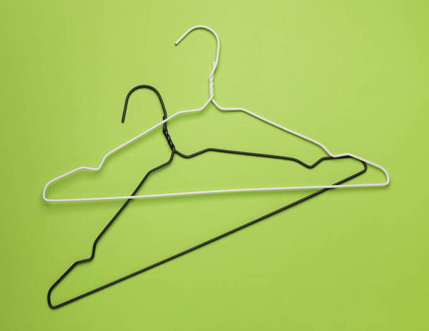 Empty clothes hangers on green background, flat lay - Foto, imagen