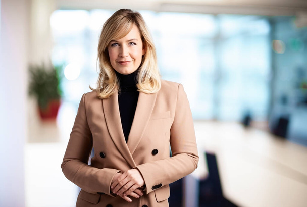 Potrait shot of beautiful blond haired businesswoman wearing turtleneck sweater and blazer while standing at the boardroom. - Fotoğraf, Görsel