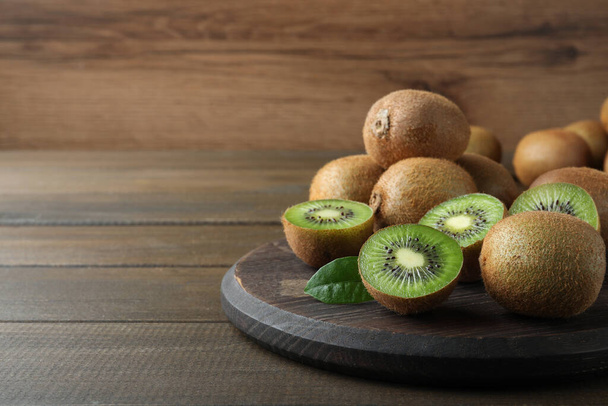Fresh ripe kiwis on wooden table, space for text - Photo, image