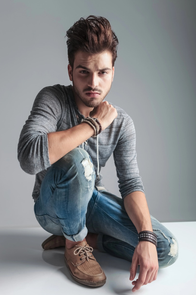 Handsome fashion man relaxing on grey studio background - Photo, Image