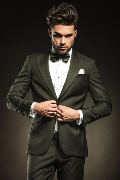 Young elegant business man arranging his tuxedo. - Photo, Image