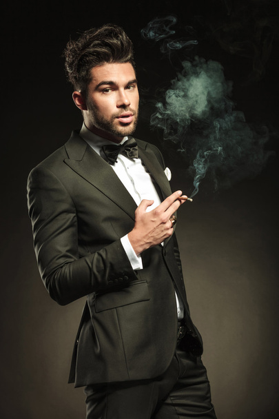 Business man holding a cigarette in his right hand - Photo, Image