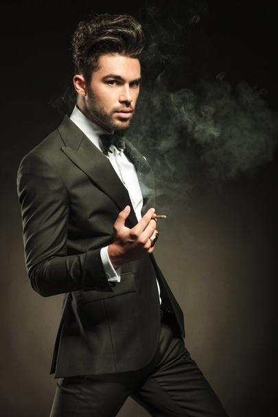 attraktiver Geschäftsmann Zigarette in der Hand, vorwärts gehend - Foto, Bild