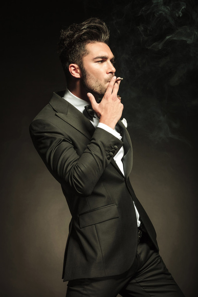 Handsome business man smoking a cigarette - Фото, зображення