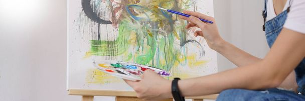 Kreative Kunstkonzept, junge asiatische Frau mit Pinsel mit Farbpalette, um Kunstwerke zu zeichnen. - Foto, Bild