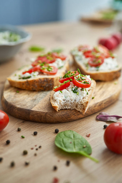 Close up of bitten sandwich with cottage cheese  on wooden board - Photo, image