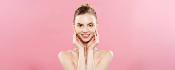 Beauty Concept: hermosa mujer caucásica con piel limpia, maquillaje natural aislado sobre fondo rosa brillante con espacio para copiar
. - Foto, Imagen