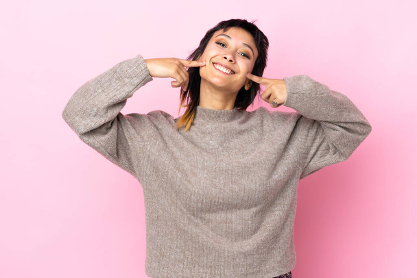 Young Uruguayan woman over isolated pink background smiling with a happy and pleasant expression - Foto, Imagen
