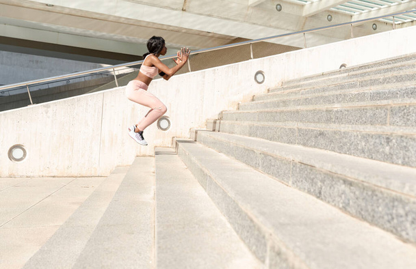 Fitness, spor, egzersiz ve yaşam tarzı konsepti - şehirdeki şehir merdivenlerinde atlayan kadın - Fotoğraf, Görsel