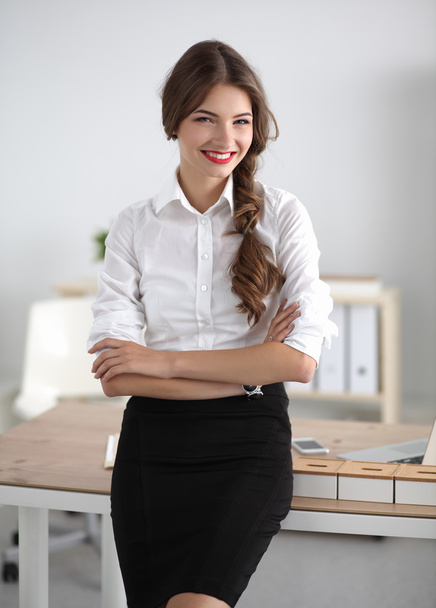 Attractive businesswoman with her arms crossed  standing in office - Photo, Image