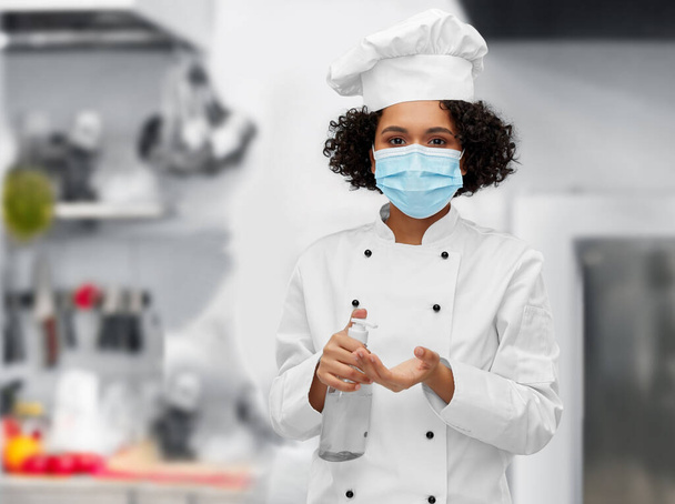 female chef in mask with hand sanitizer or soap - Фото, зображення