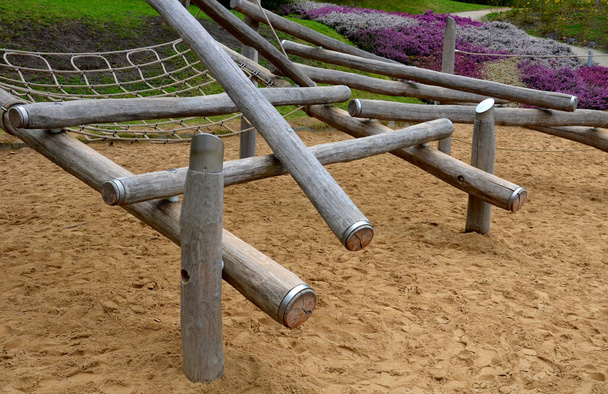 wooden obstacle course for children made of solid poles and logs. clade is finished at end with a metal ring preventing the edges from cracking when wood dries. can catch a child and strangle himself - Photo, Image