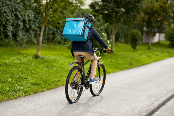 food delivery man with bag riding bicycle - Foto, afbeelding