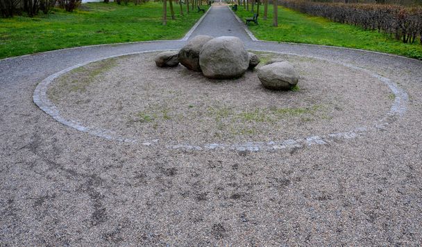 prevention of vehicles entering the pedestrian zone, cycle path in winter. placing a large boulder in the middle of the road, stones at a roundabout in a granite rock park - Foto, Imagem