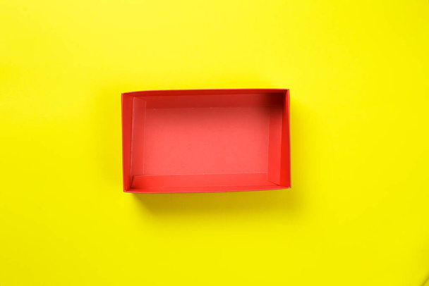 lege rode doos op een gele achtergrond. kleurrijke heldere foto. - Foto, afbeelding