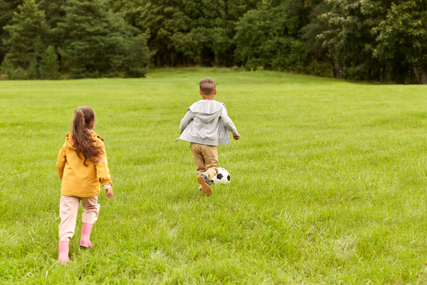 little children with ball playing soccer at park - Foto, Imagen