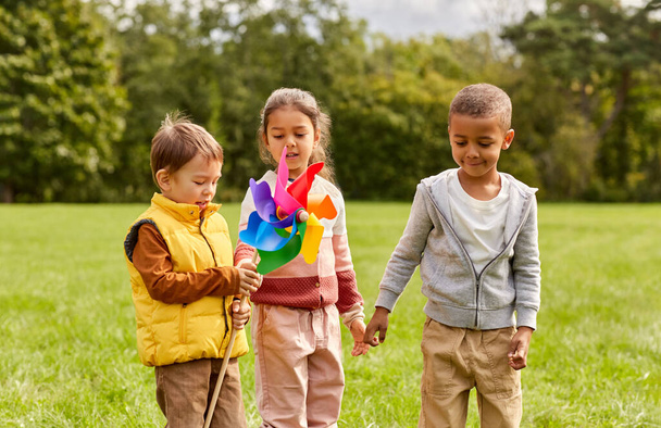 gelukkig kinderen met pinwheel hebben plezier op park - Foto, afbeelding