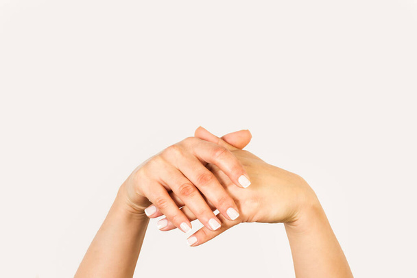 Mãos de mulher cruzadas em um fundo branco com espaço de cópia - Foto, Imagem